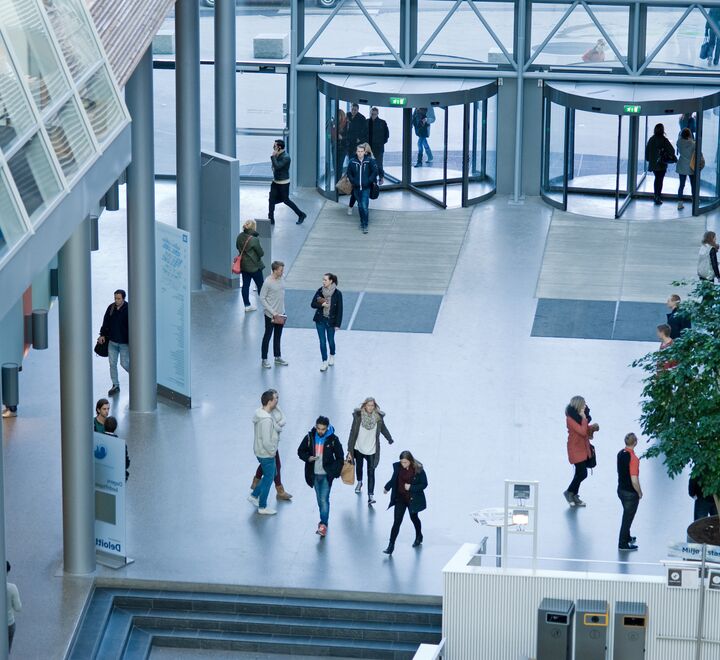 Bilde tatt ovenfra av hovedinngangen til campus Oslo. Studenter kommer inn gjennom hovedinngangen.