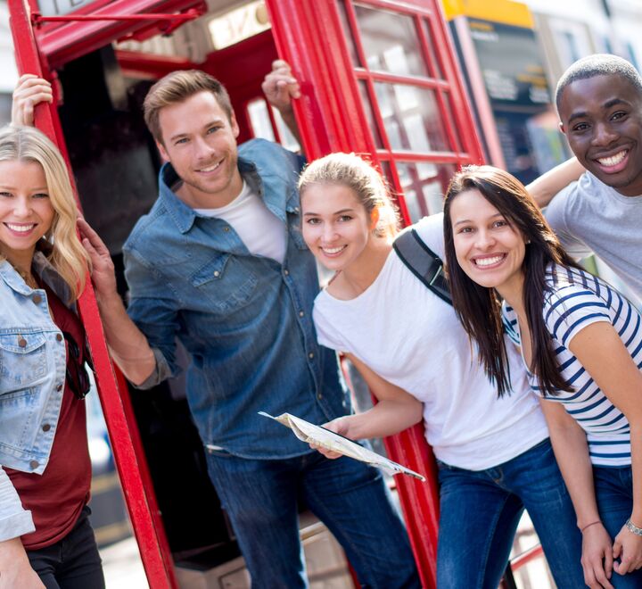 En gruppe studenter foran en telefonkiosk i London