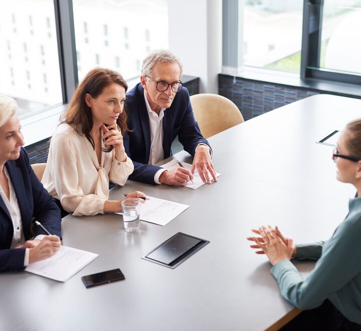 En jobbsøker blir intervjuet av tre personer rundt et bord