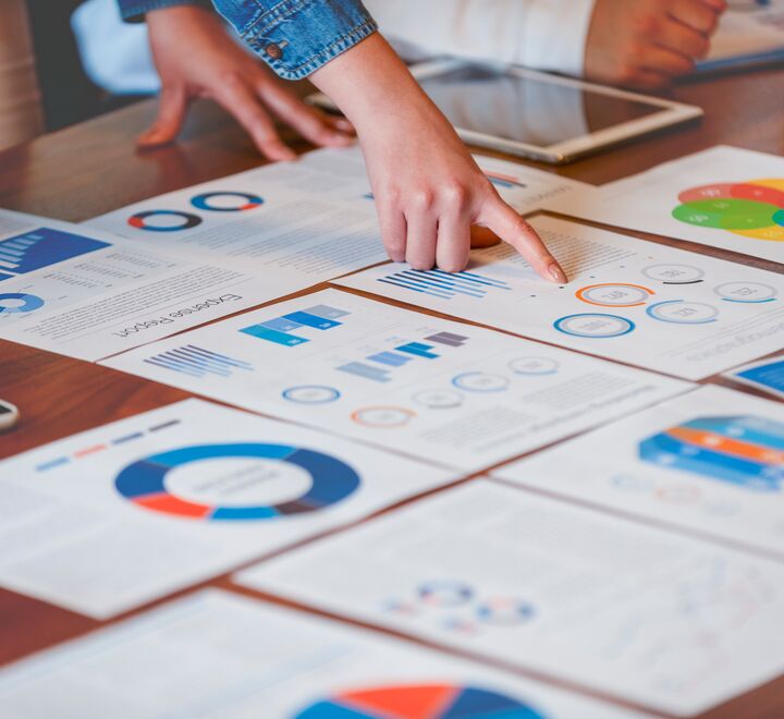 Person peker på et bord med dokumenter