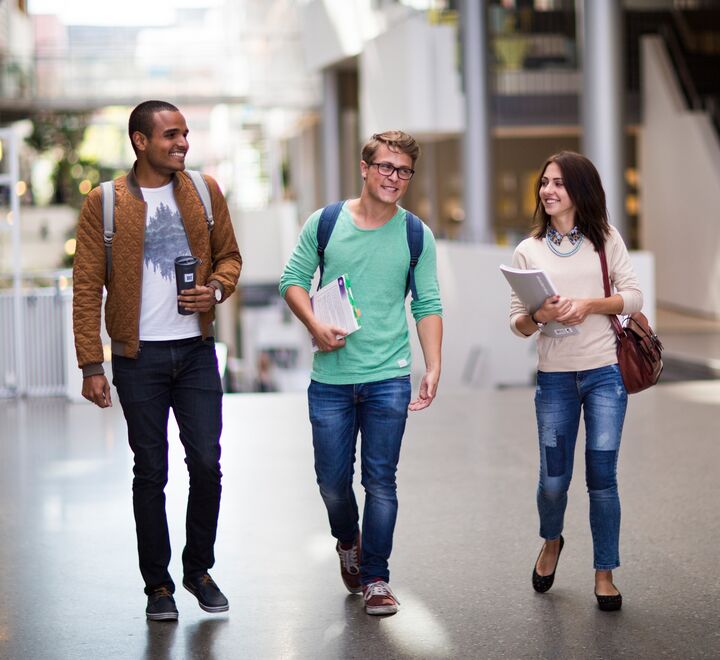 Smilende studenter som går gjennom campus Oslo