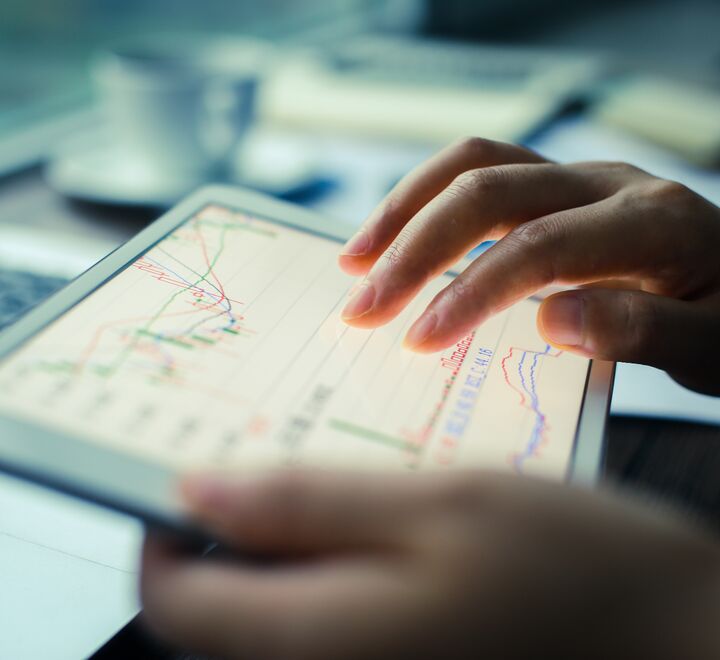 Hands holding a tablet with numbers on