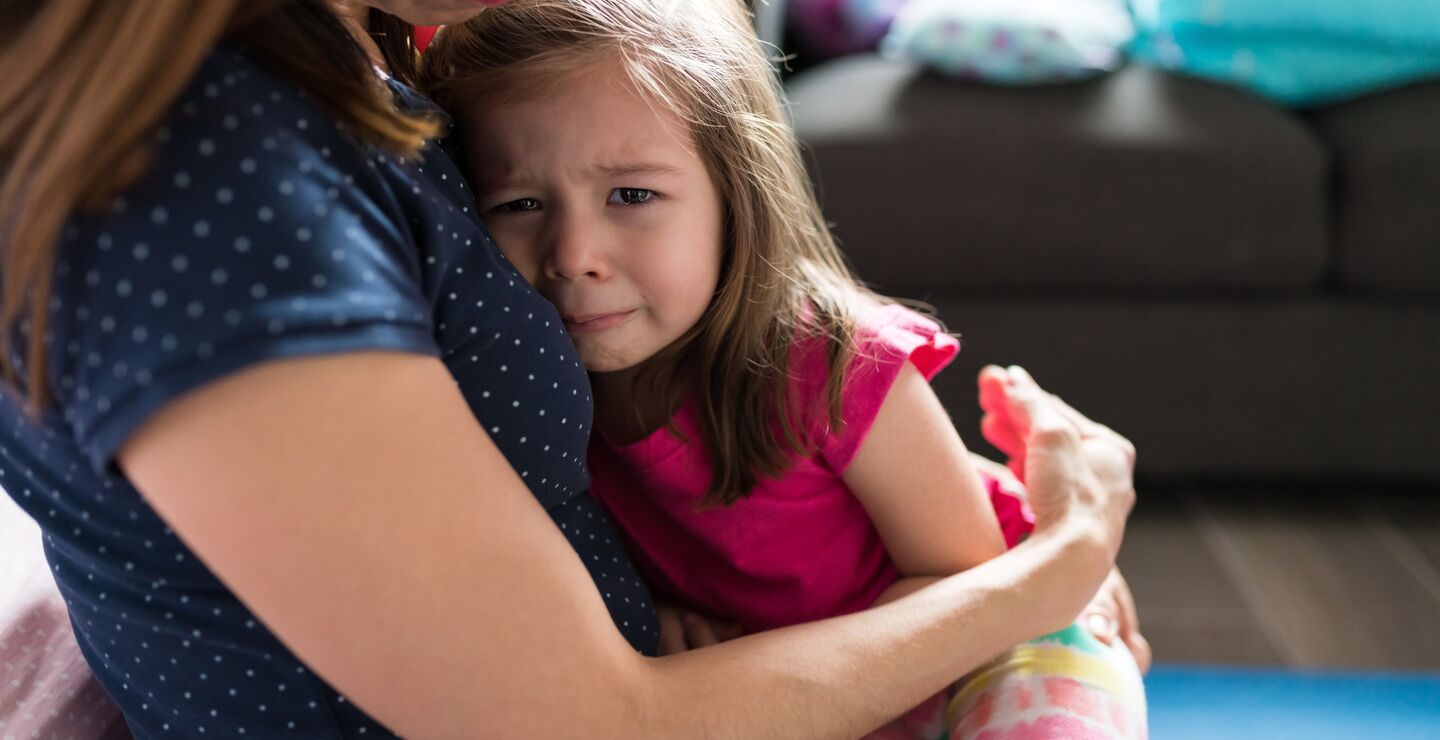 Gråtende jente i fanget på sin mamma