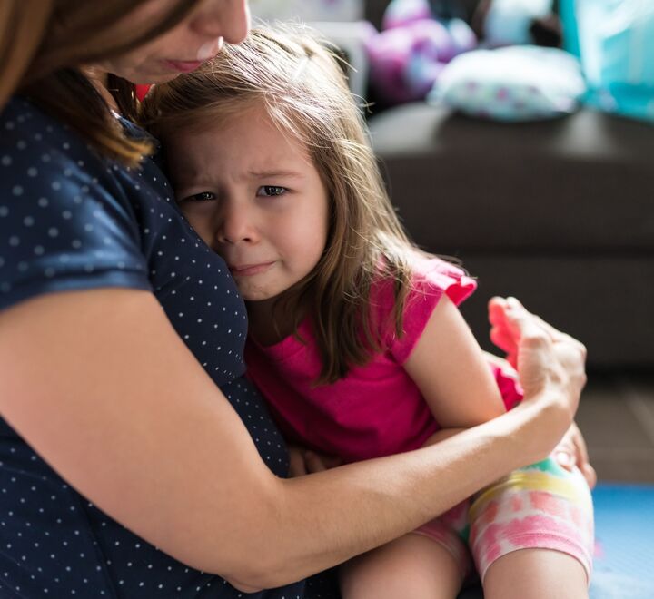 Gråtende jente i fanget på sin mamma