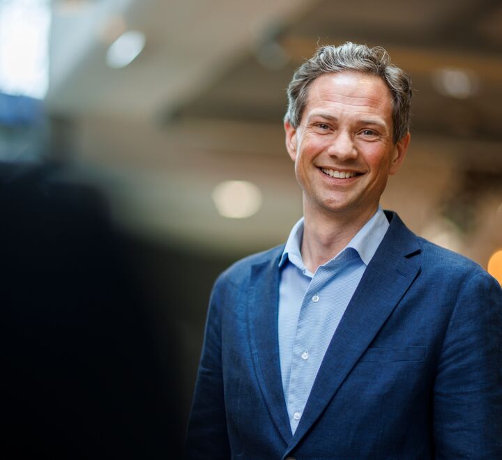 Bilde av stående, smilende mann