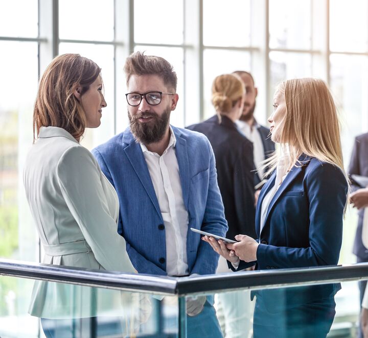 Ansatte som står å prater i et kontorlandskap