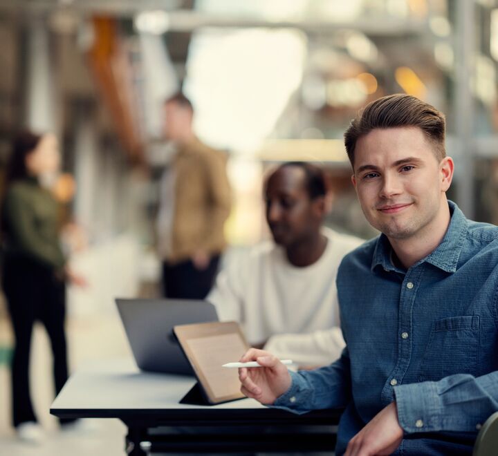 Mannlig student smiler til kamera