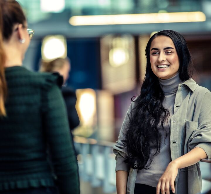 Studenter som sitter på campus og snakker sammen