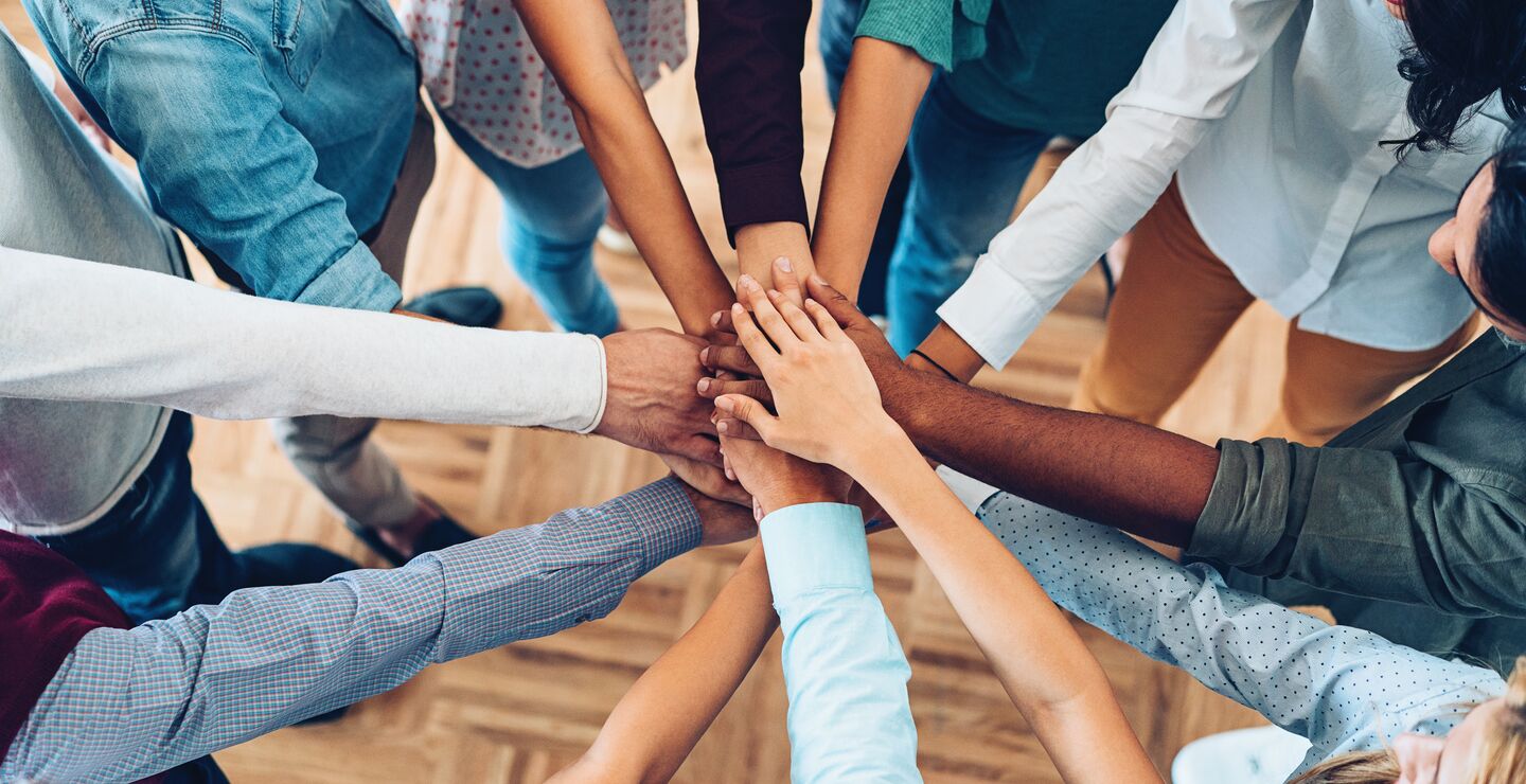 En gruppe mennesker samler hender