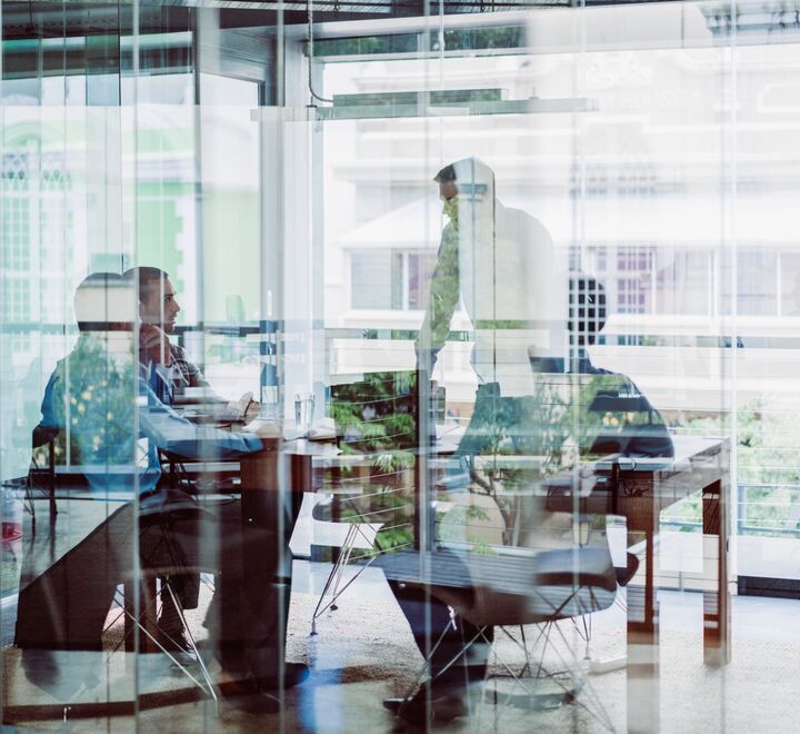 People in a meeting behind glass