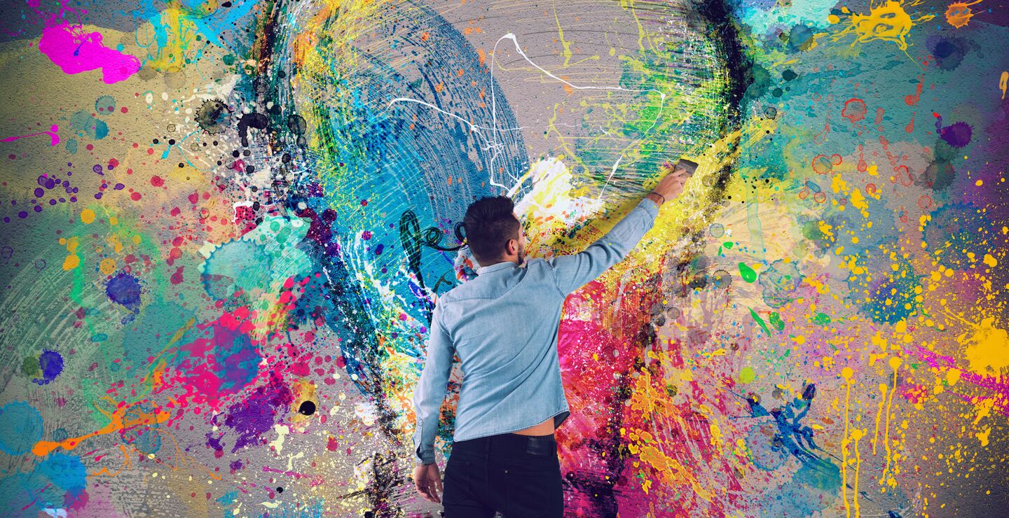 Mann maler en fargerik lyspære