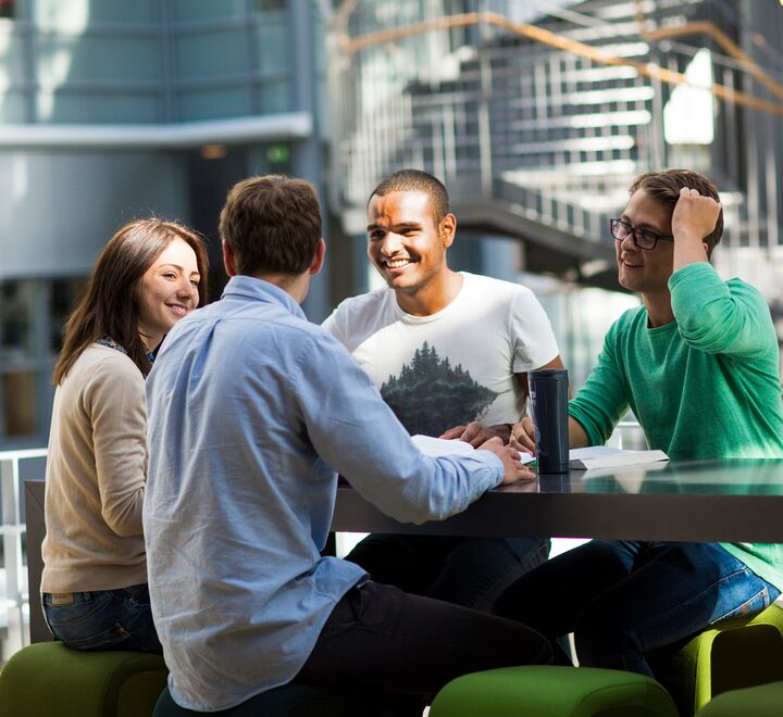 Students talking wit each other at a table at BI Oslo 