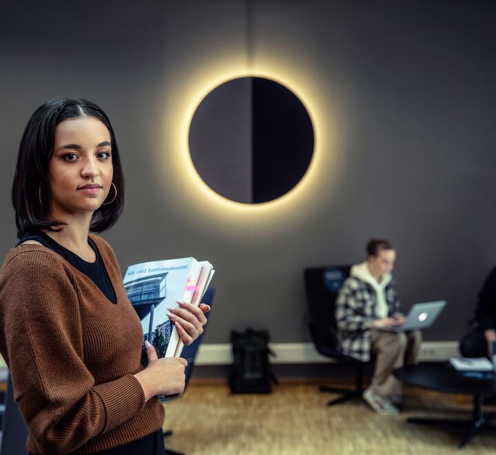 Bestemt jente som holder bøker