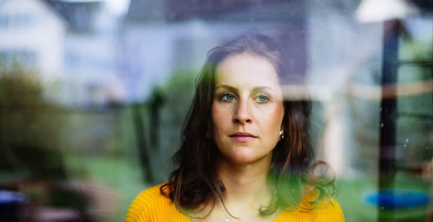 Woman looks thoughtfully through the window.