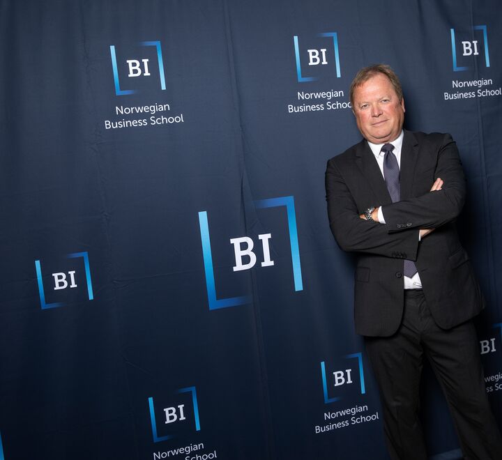 Rektor Inge Jan Henjesand som står foran en bakgrunn med BI logoen 