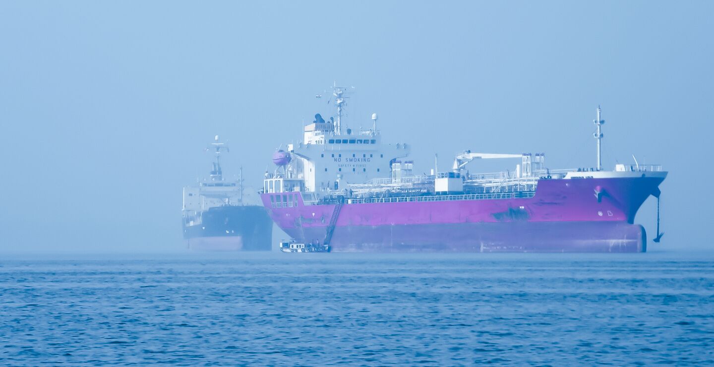 To lasteskip ved siden av hverandre på havet.