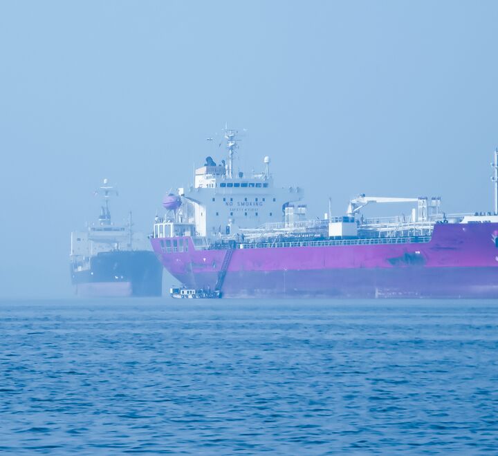 To lasteskip ved siden av hverandre på havet.