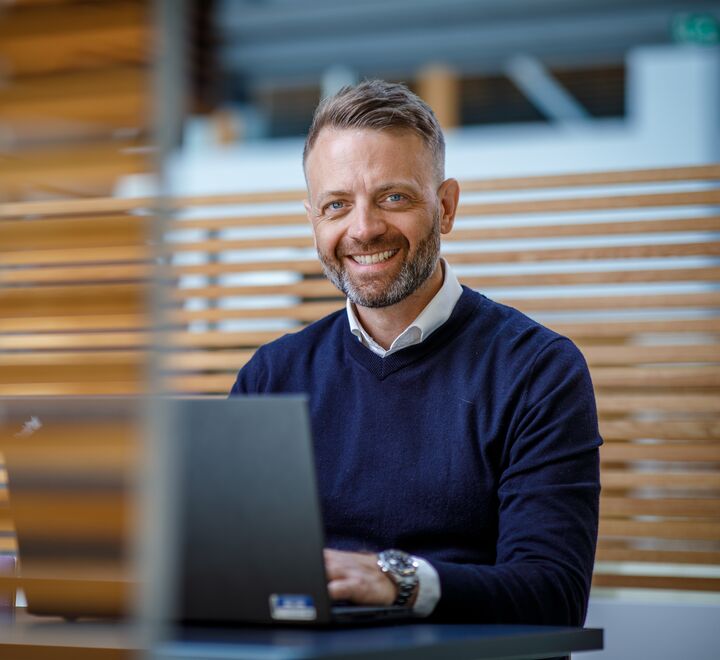 Bilde av en mann foran en PC