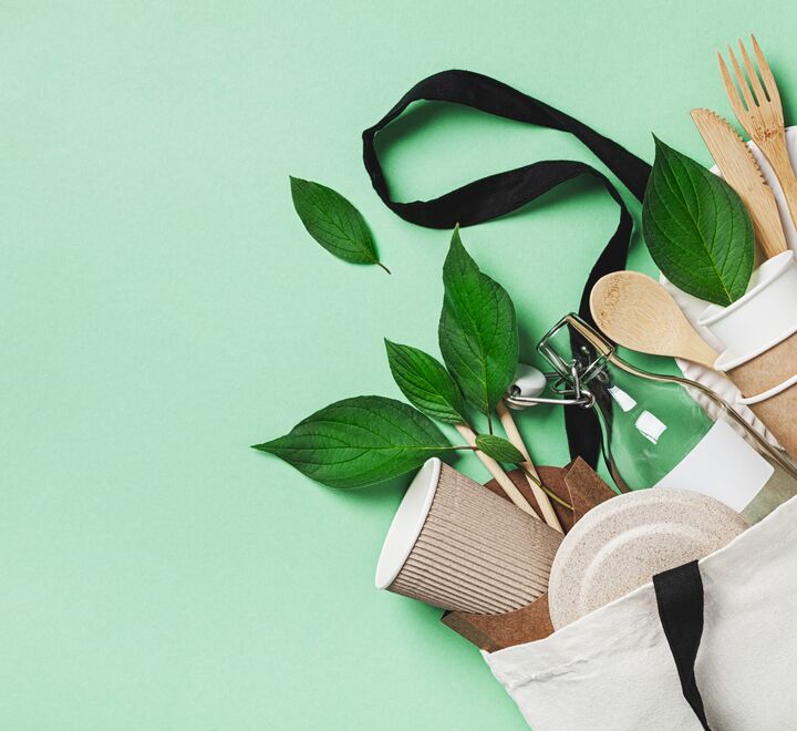  Plastfritt sett med øko-bomullspose, glasskrukke, grønne blader og resirkulert servise ovenfra