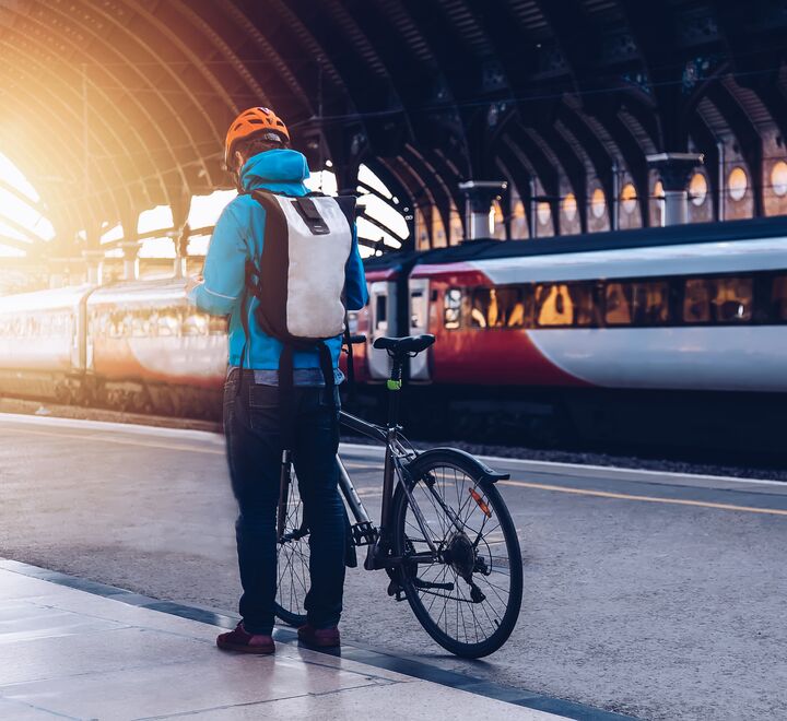 Mann med sykkel på togstasjon 