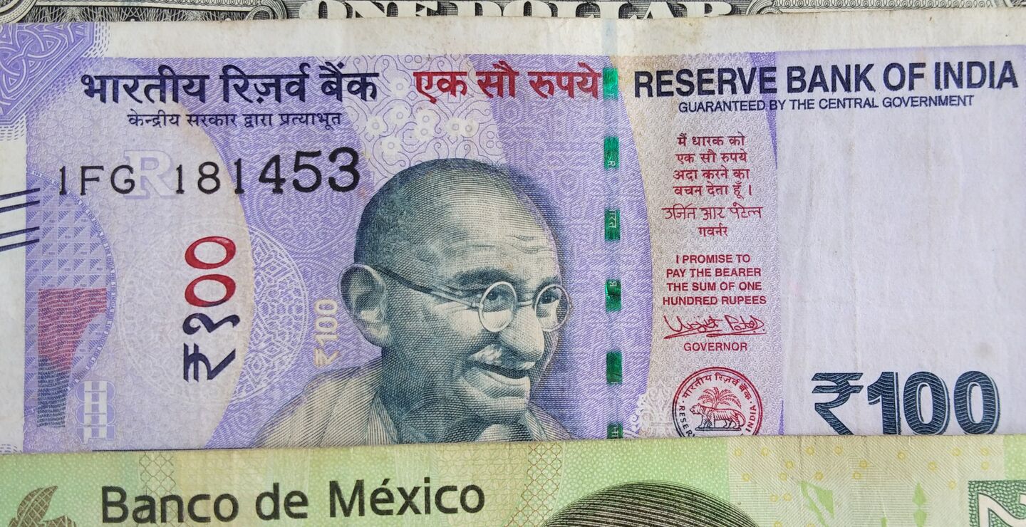 A dollar bill, a rupee bill and a peso bill