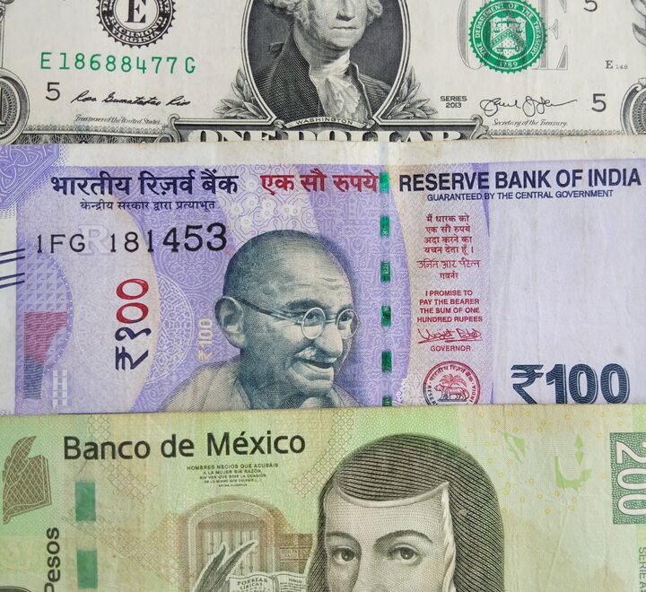 A dollar bill, a rupee bill and a peso bill