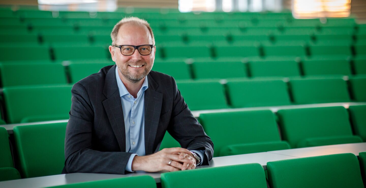 Professor Bjørn Erik Mørk sittende i et auditorium