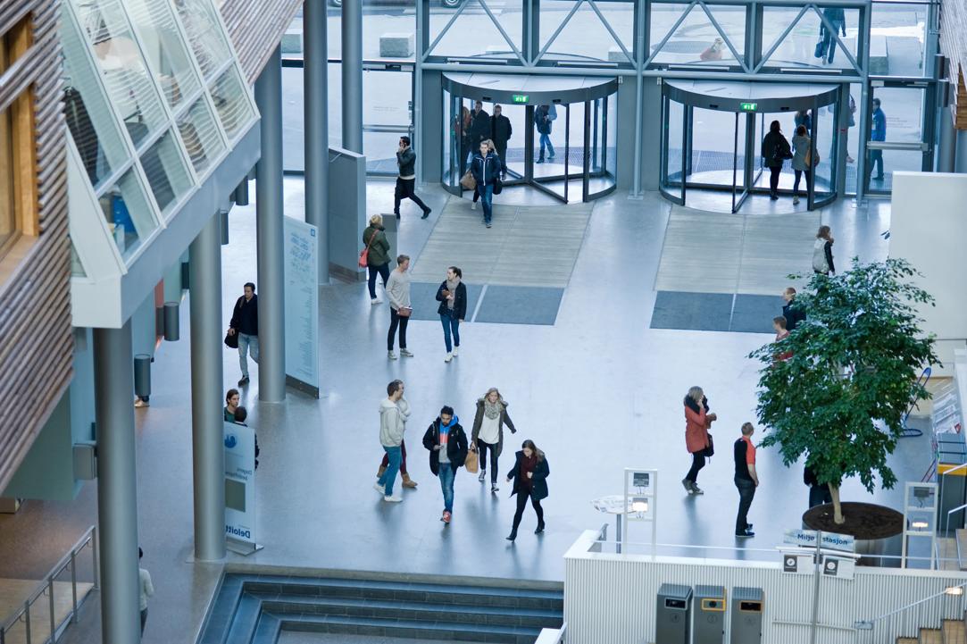 Bilde tatt ovenfra av hovedinngangen til campus Oslo. Studenter kommer inn gjennom hovedinngangen.