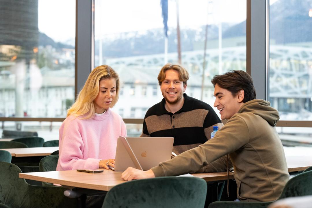 Three students with a laptop computer