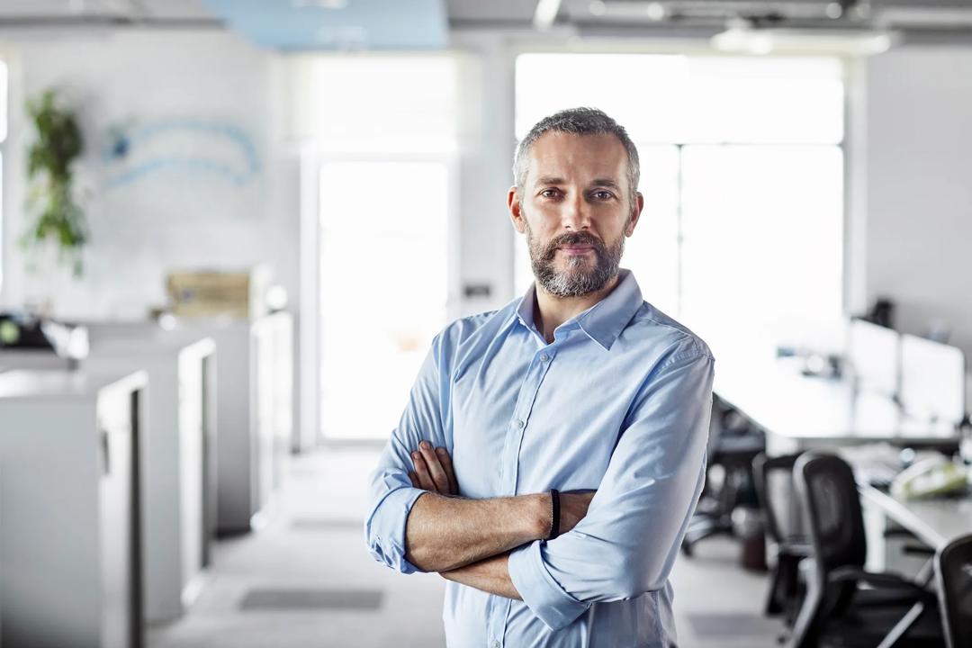 Bilde av en entreprenør som står på kontoret.