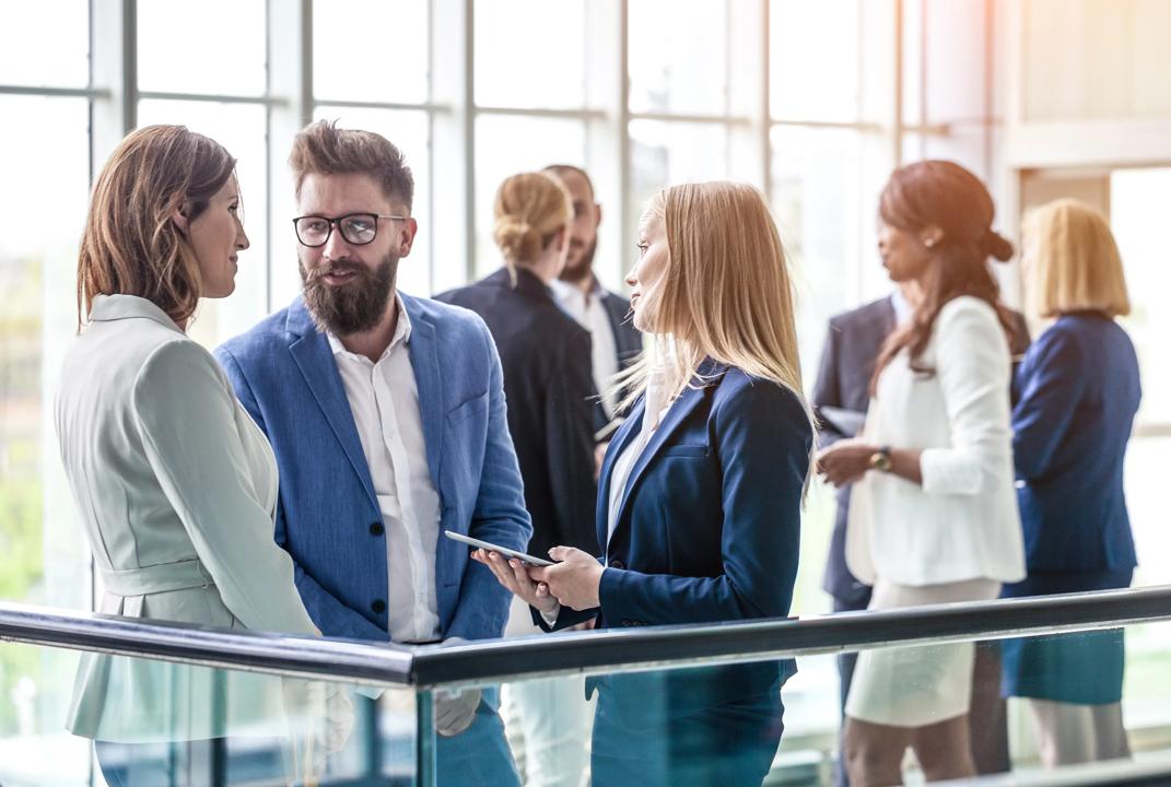 Well-dressed people in meeting talking together