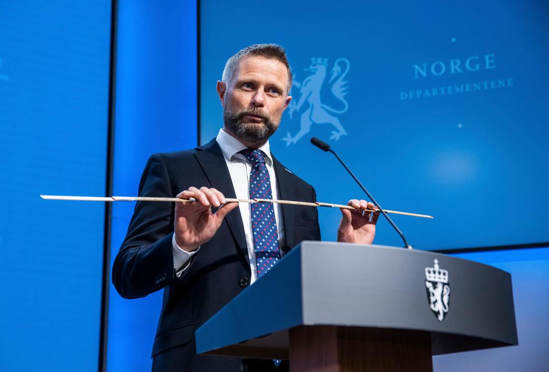 Tidligere helseminister Bent Høie demonstrerer "meter'n" med en tommestokk under en pressekonferanse.