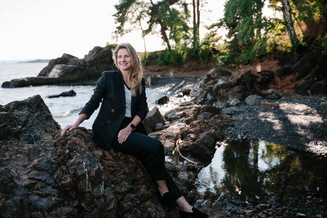 Marta sitting on a rock in the ocean