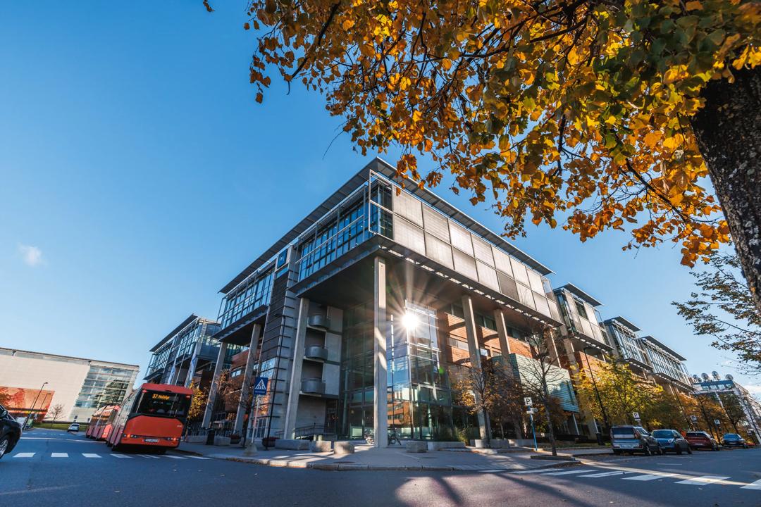 Outside of campus Oslo, image of the building with orange leaves from the tree in front. Autumn.