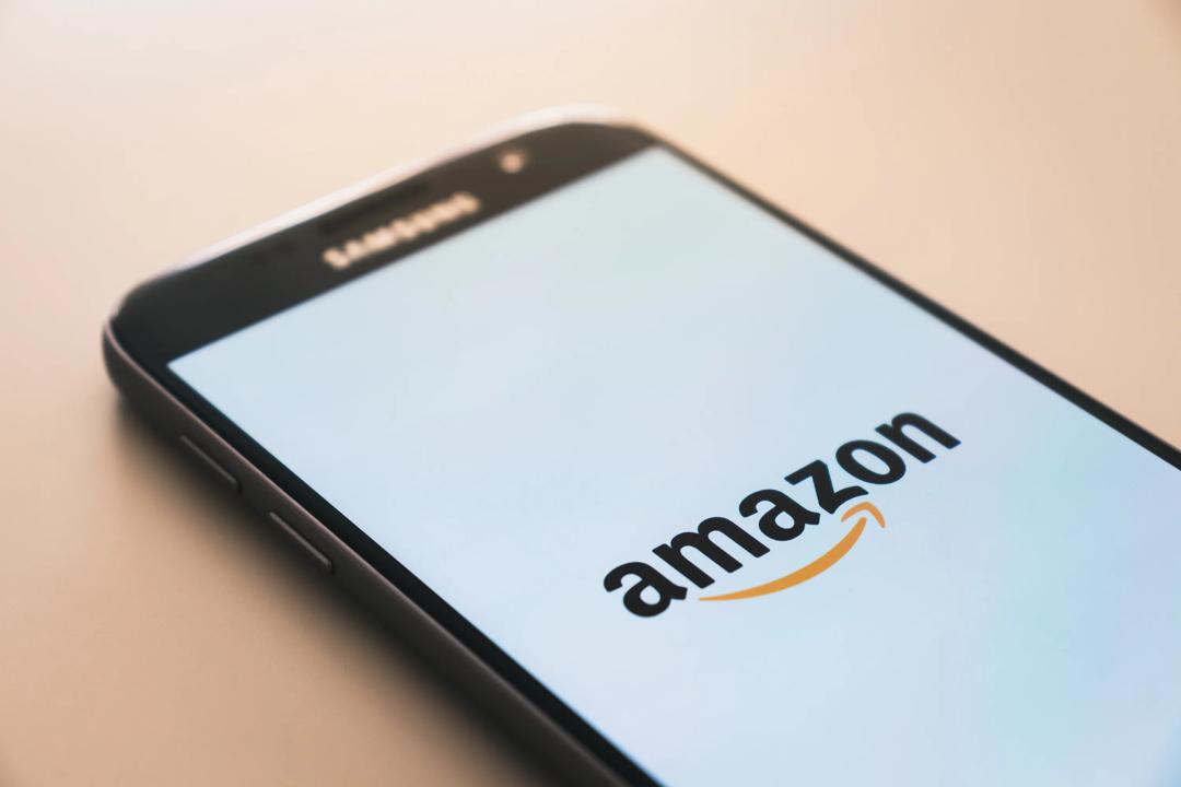 Det spekuleres fortsatt rundt når Amazon for alvor kommer til å etablere seg i Norge, og ikke om de kommer. Bilde av en Iphone med Amazon logo. Foto: Christian Wiediger, Unsplash.com.