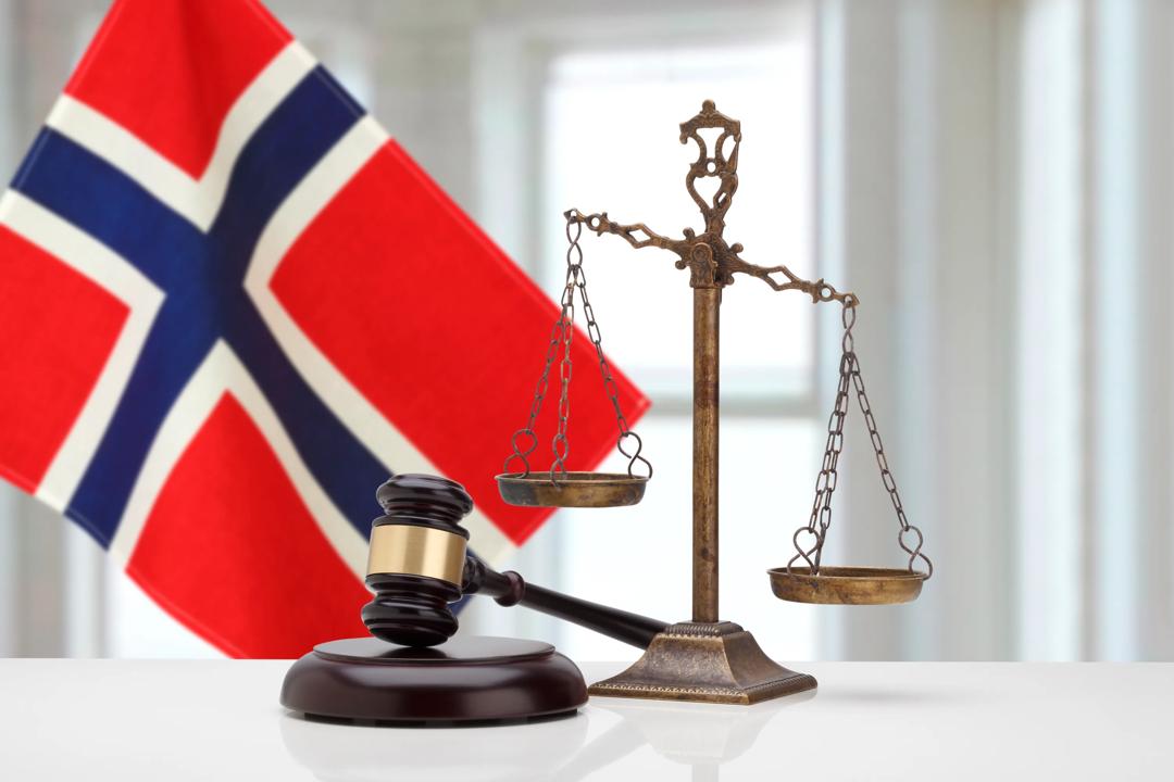 Bilde av dommerklubbe med det norske flagg i bakgrunnen