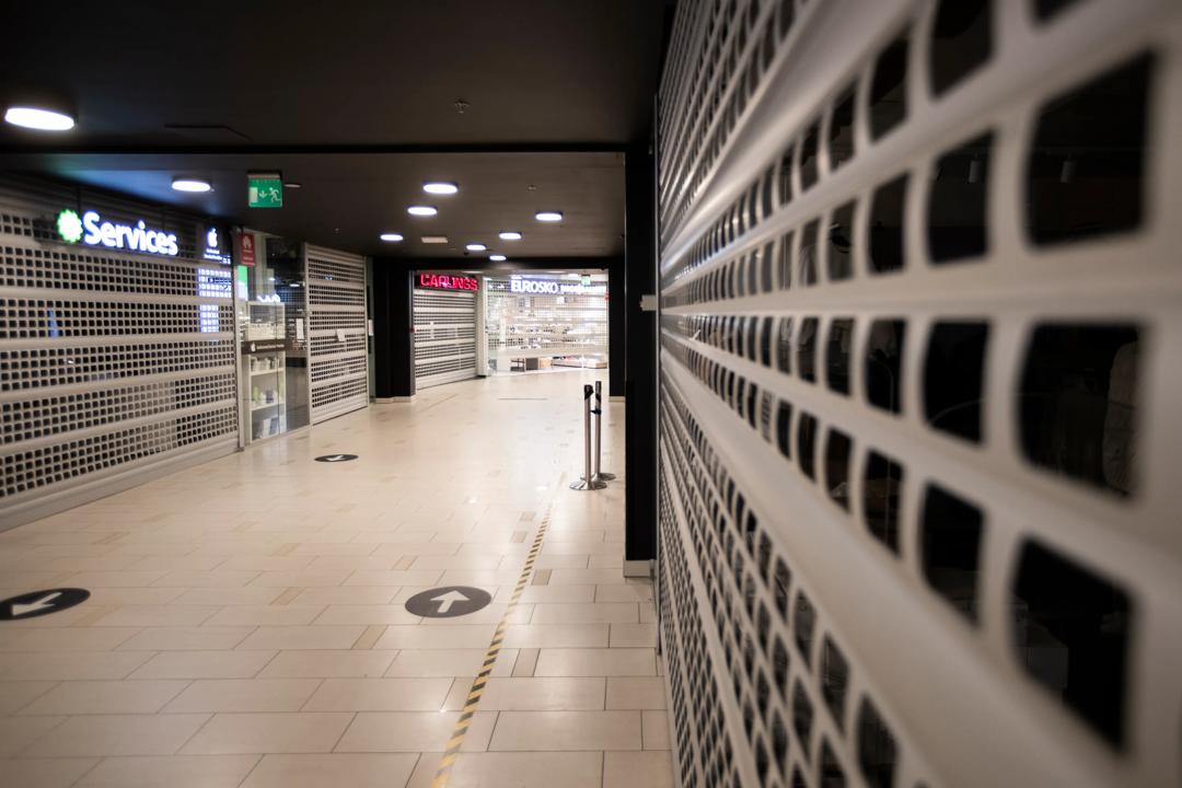 Bilde tatt inne i et tomt kjøpesenter med stengte butikker.