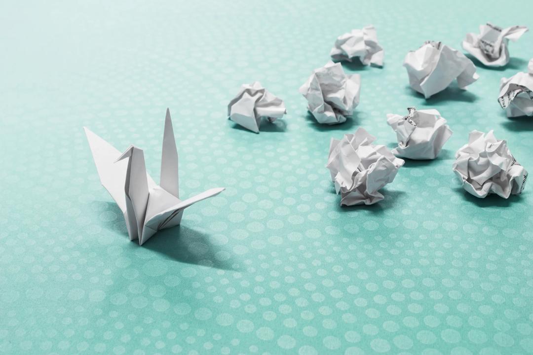 Origami av en svane sammen med mange baller krøllet papir