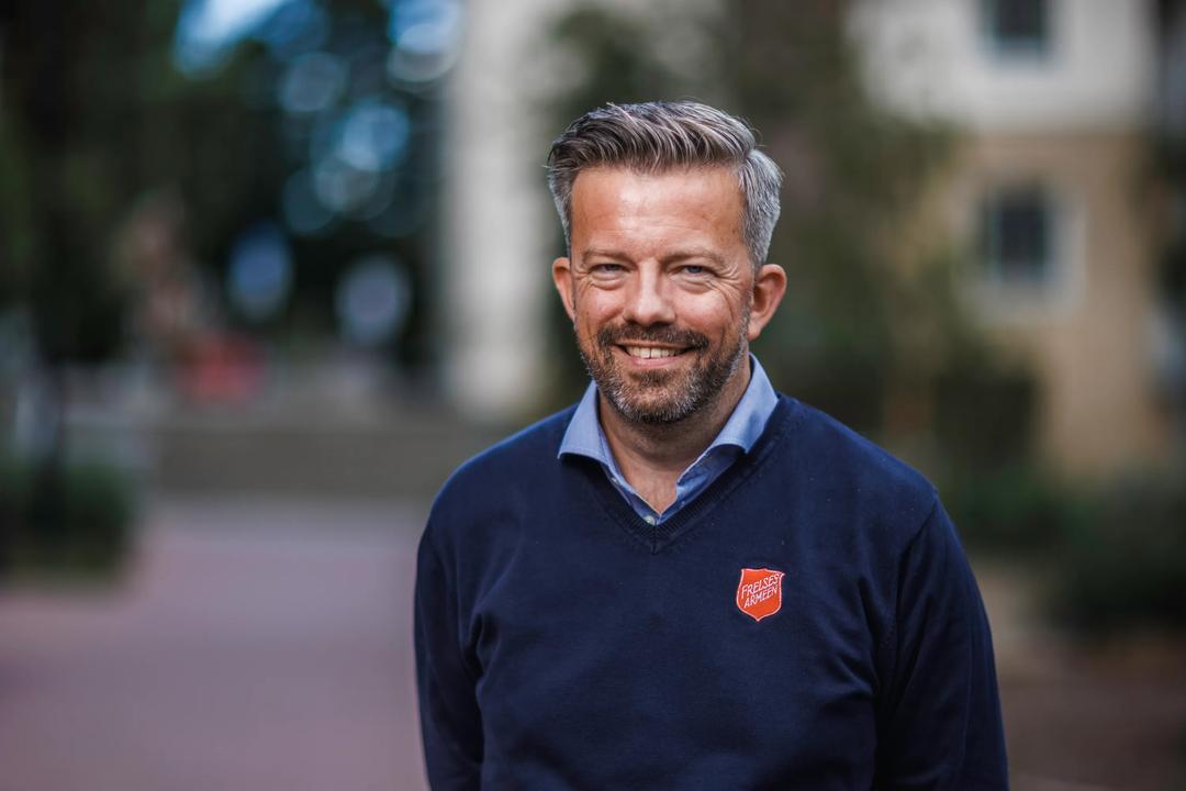 Geir Smith-Solevåg utendørs med Frelsesarmeens logo på skjorten.