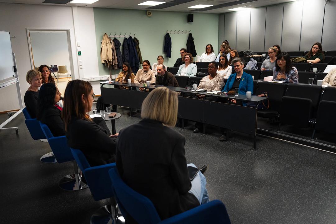 Behind the penal discussants, image of the audience