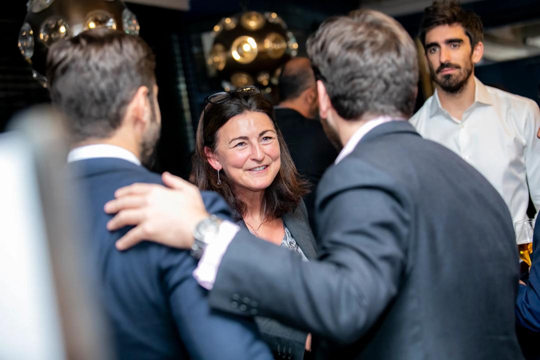 Image of a woman talking to two people. The image is from a networking event in Madrid.