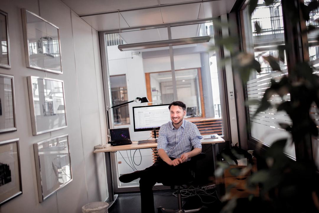 A man smiling at his desk
