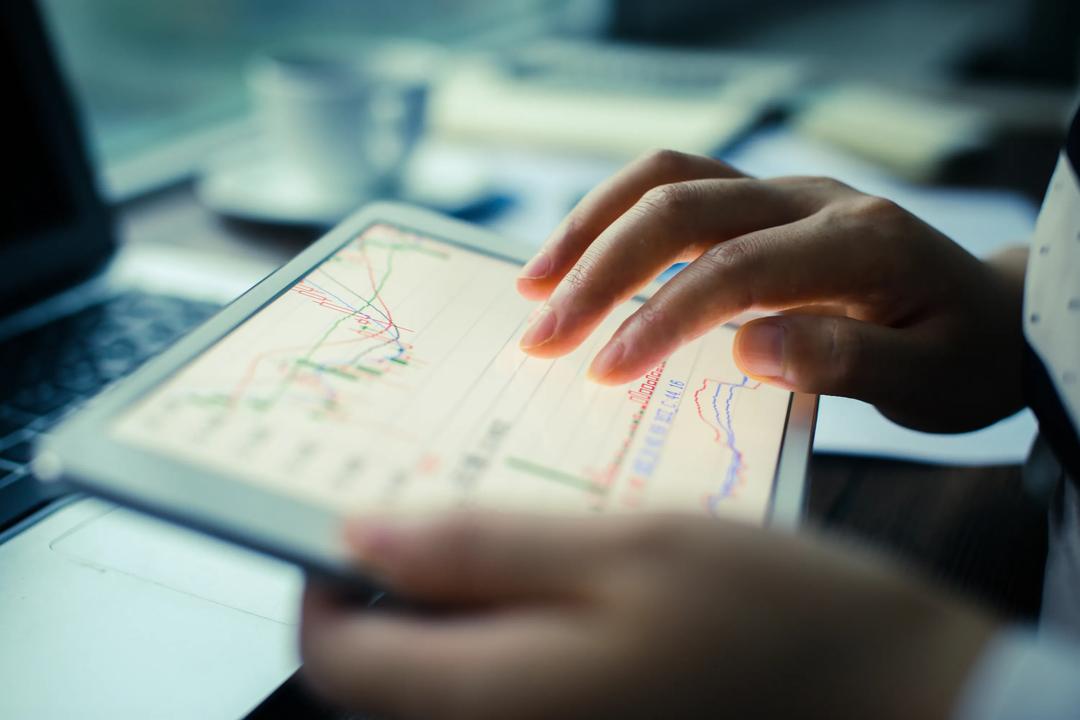 Hands holding a tablet with numbers on