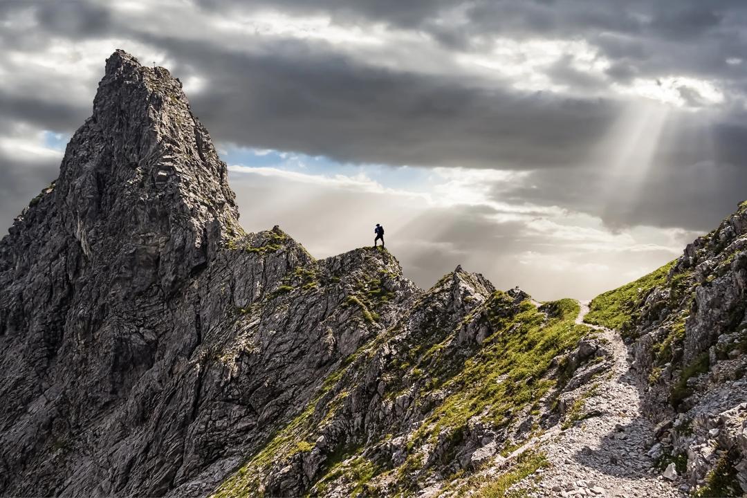 Man standing at the top of a mountain with a great view..