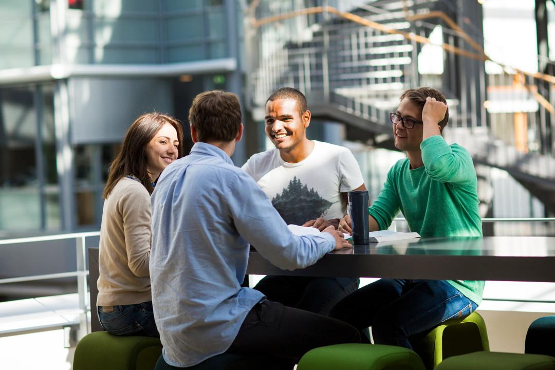Students talking wit each other at a table at BI Oslo 