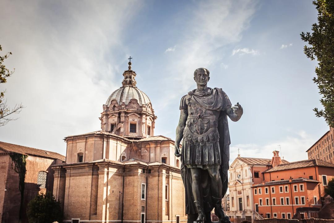 Julius Caesar statue med kirken Saint Luca e Martina i bakgrunnen.