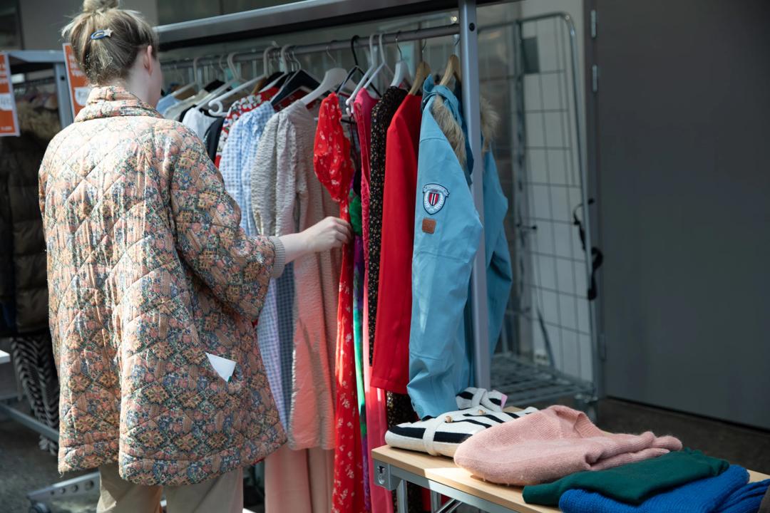 A woman looking at clothes at the second-hand market in Spring 2024