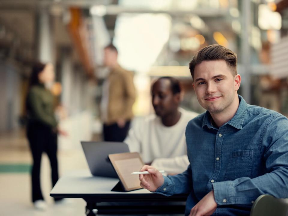 Mannlig student smiler til kamera