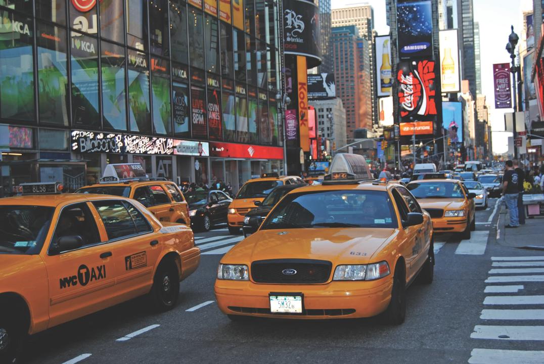 En travel gate i New York med gule drosjer