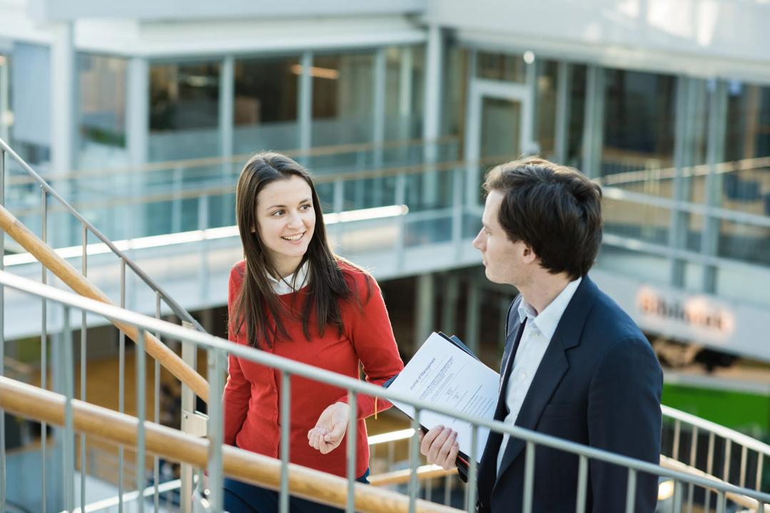 Two people walking up a staircase and talking
